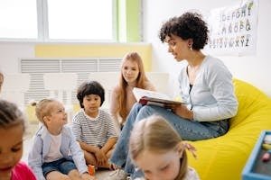 Teacher reading to preschool kids in a colorful classroom setting.